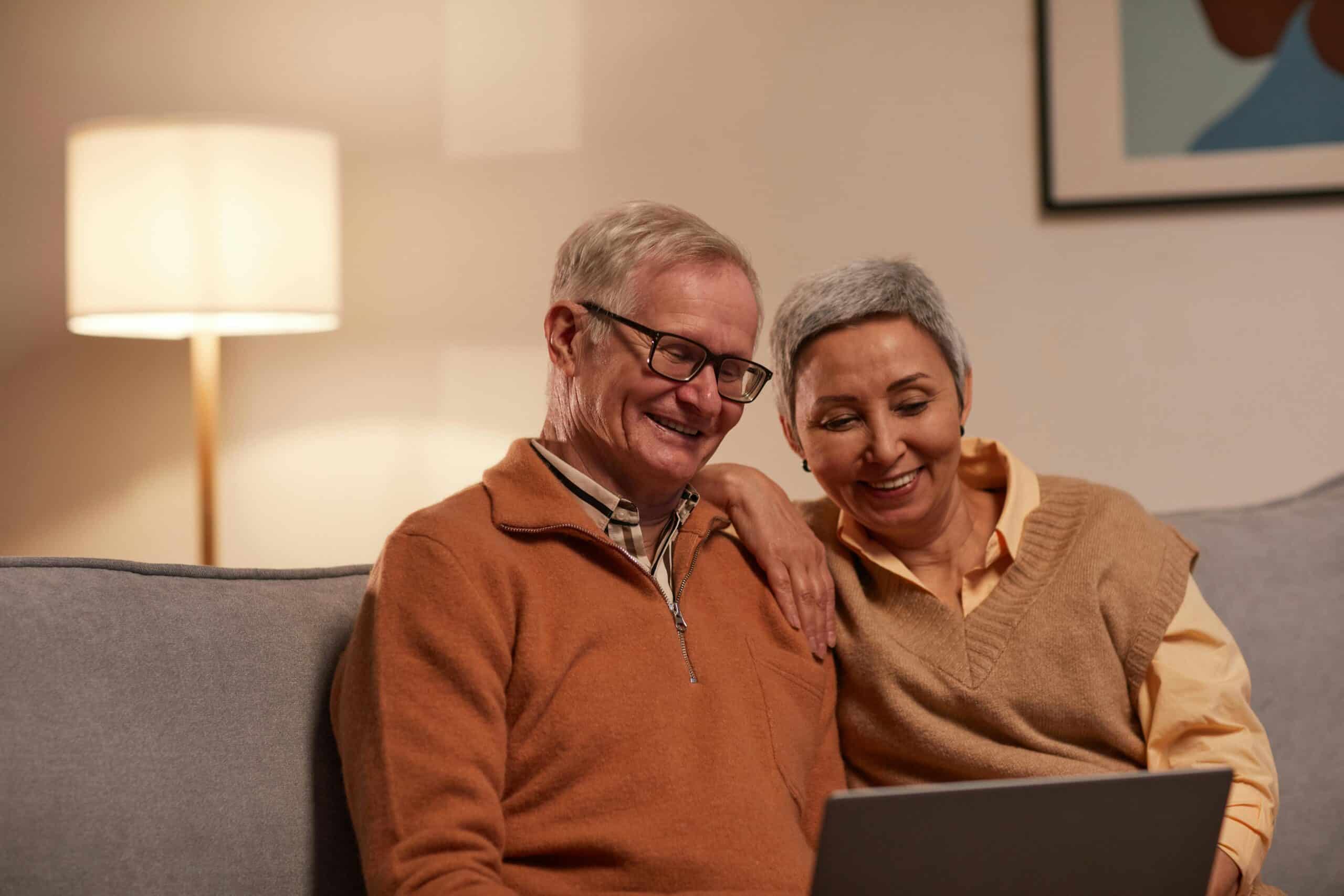 Older couple looking through communities on a laptop