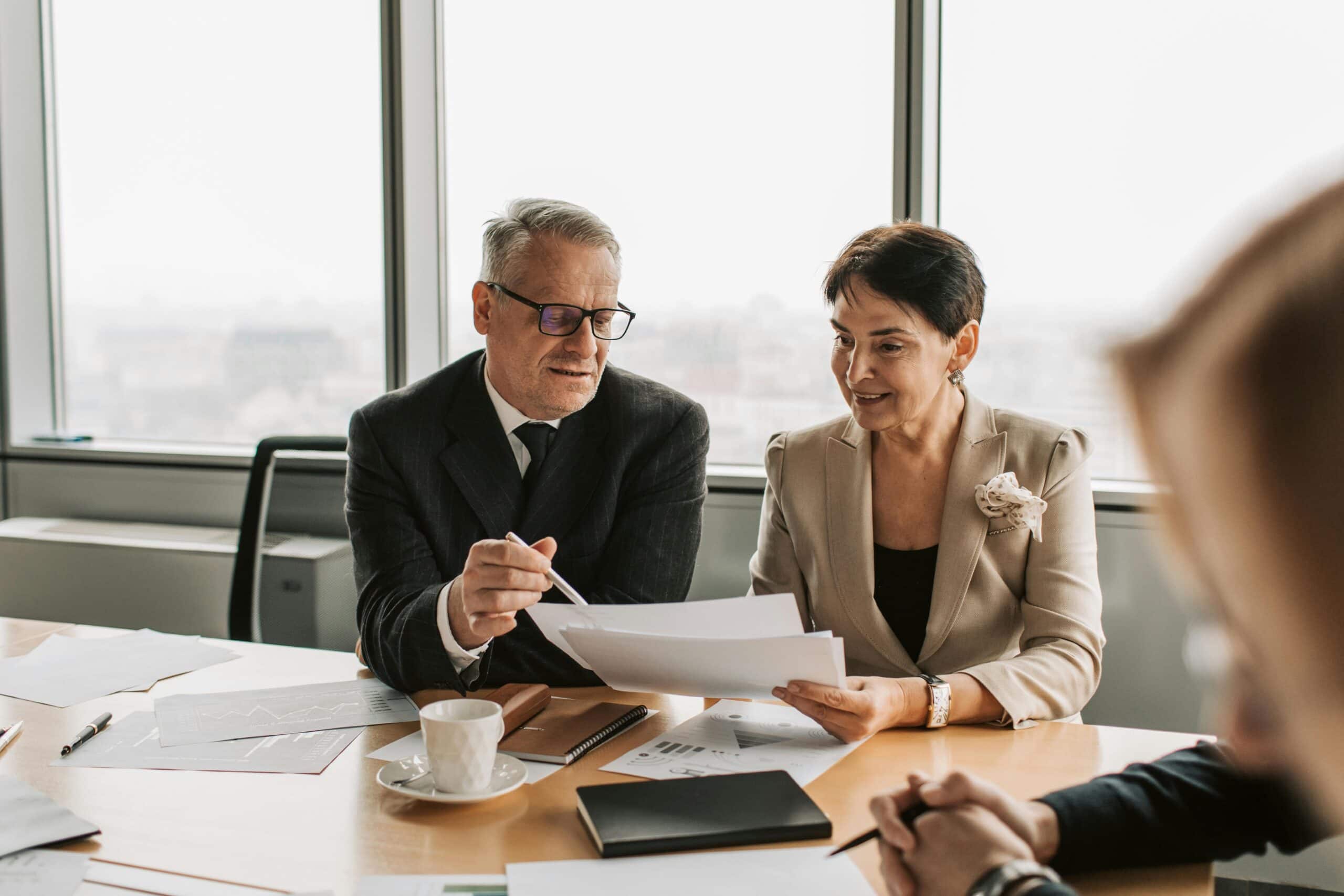 Two board members reviewing financial reports during a commercial association management meeting.
