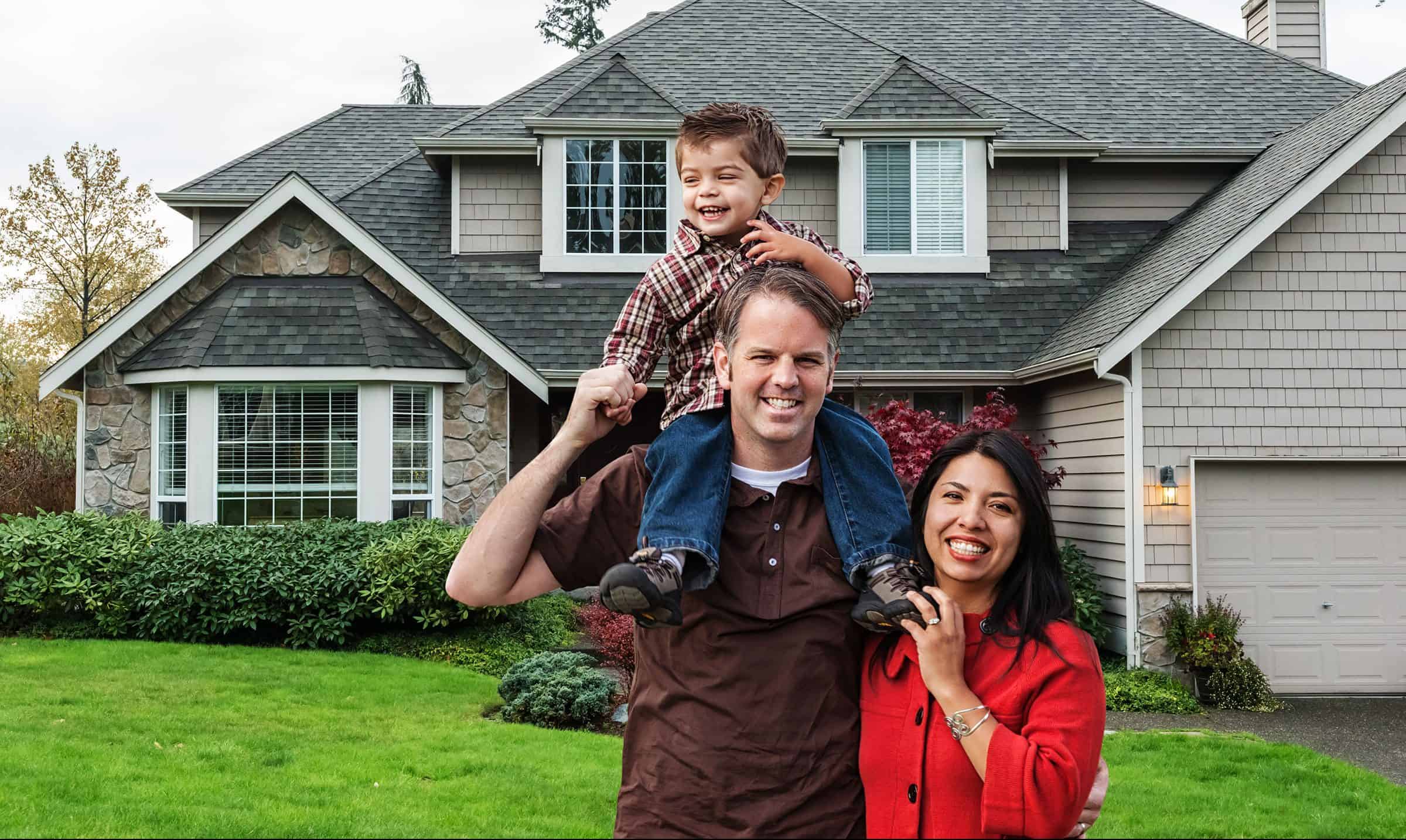 A smiling family standing in front of their home in a planned community—symbolizing resident life within an HOA environment.