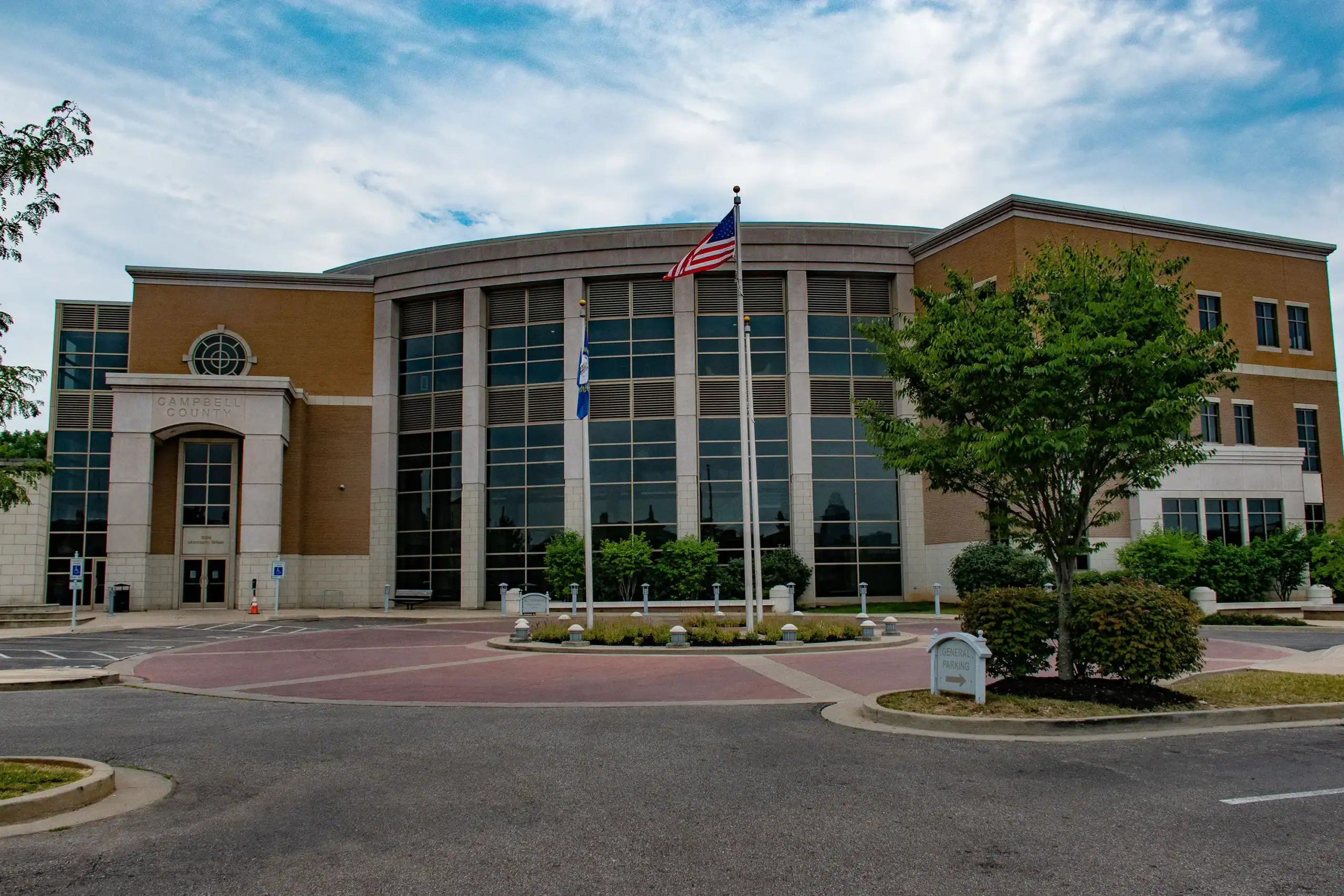 Campbell County Government Center building with glass windows, flags, and landscaped surroundings under a partly cloudy sky. Campbell County Government Center building with glass windows, flags, and landscaped surroundings under a partly cloudy sky.